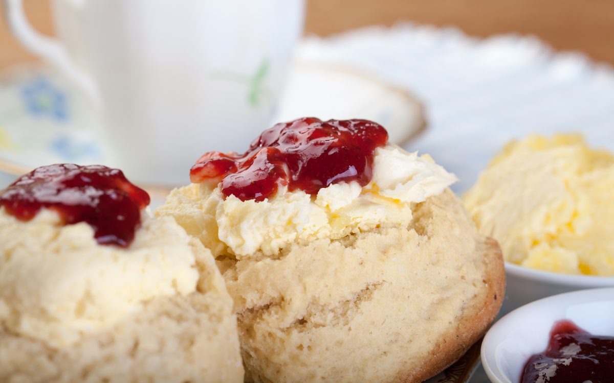 Photo of a scone topped with clotted cream and jam