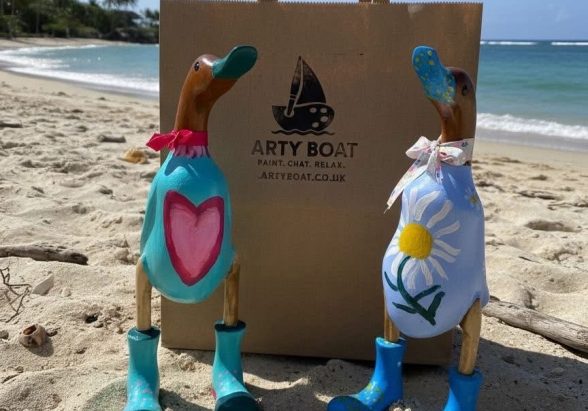 Painted wooden ducks on beach