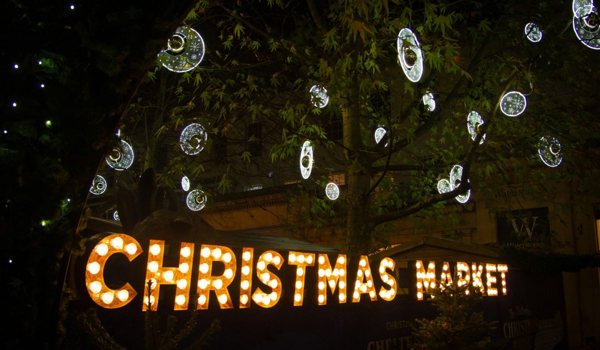 An illuminated sign of Christmas Market with silver baubles.