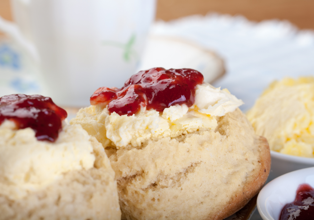 Photo of a scone topped with clotted cream and jam