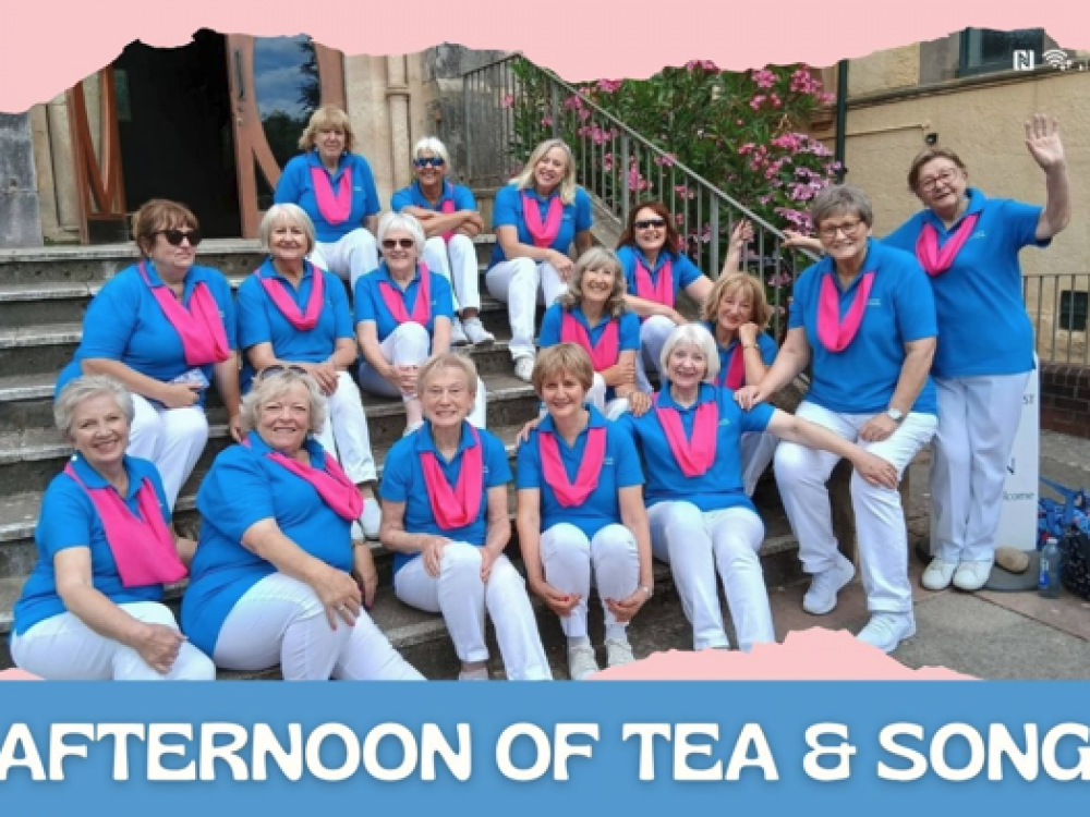Group photo of the Exmouth A Cappella Choir members sat on steps