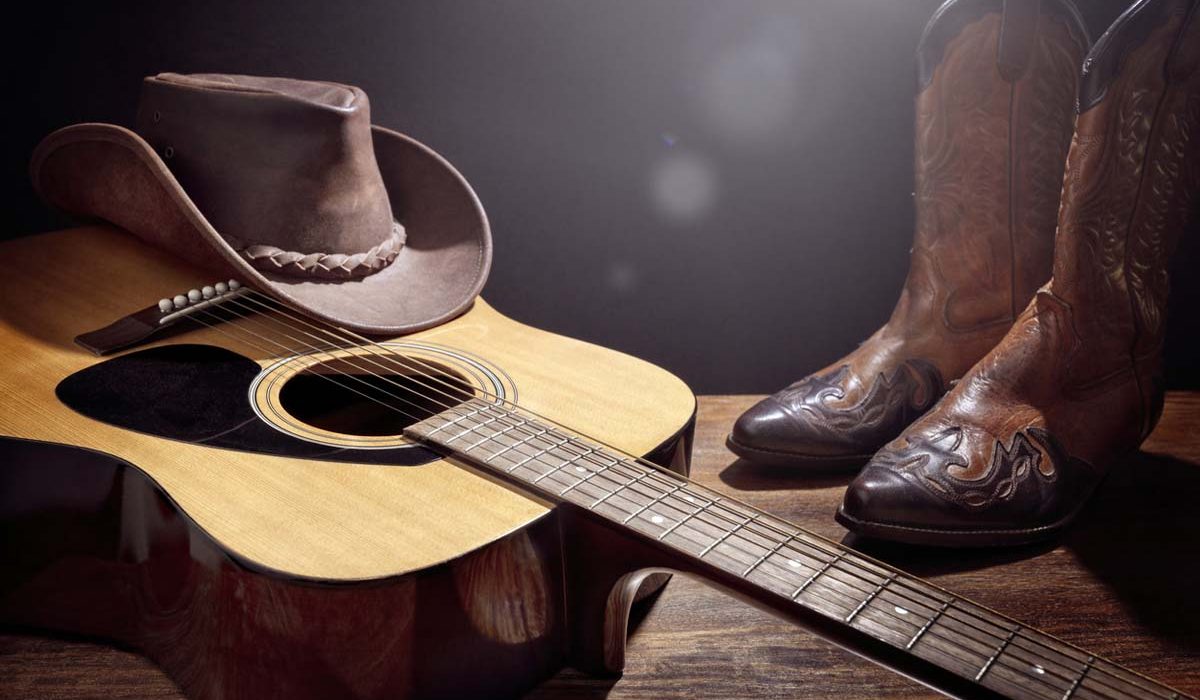 Country music festival live concert with acoustic guitar, cowboy hat and boots background