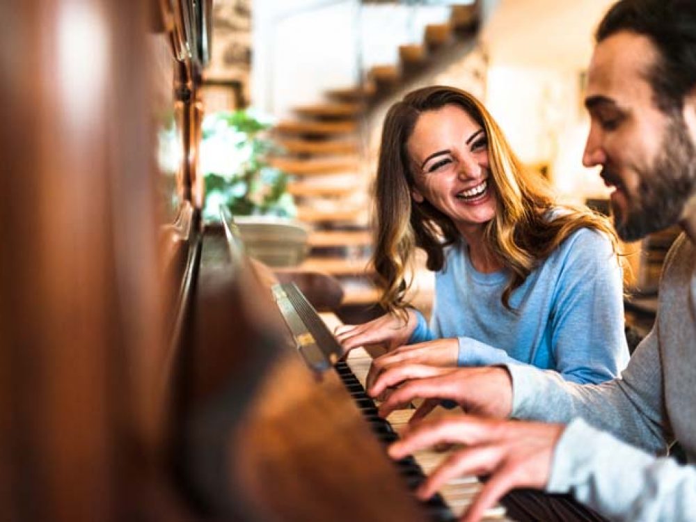 french couple playing the piano in a parisen house